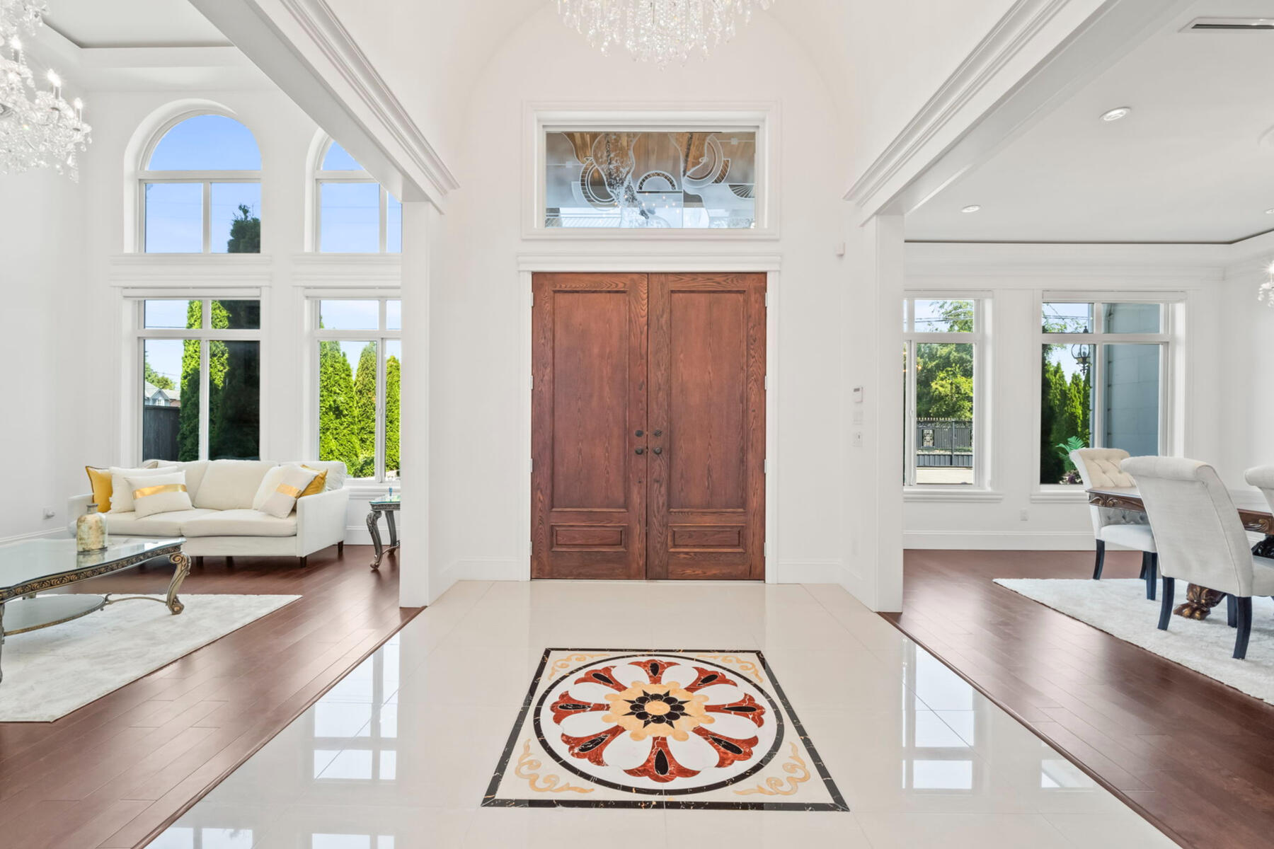 A dramatic 16-foot foyer creates an immediate sense of scale, framed by formal living and dining spaces on either side.